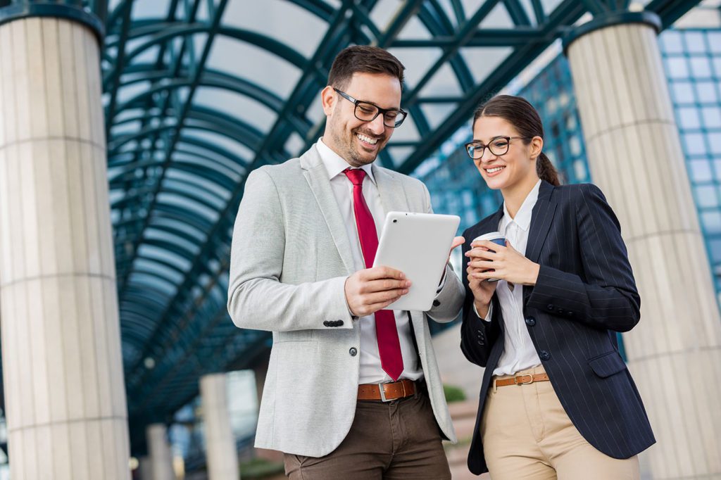 female and male employees laughing at tablet
